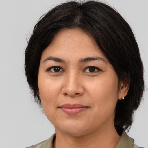 Joyful asian adult female with medium  brown hair and brown eyes