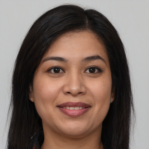 Joyful latino young-adult female with long  brown hair and brown eyes