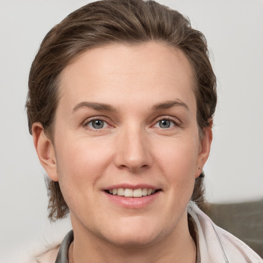 Joyful white young-adult female with medium  brown hair and grey eyes