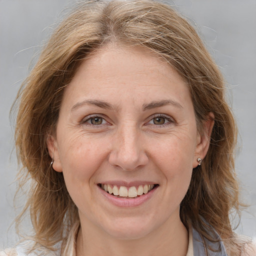 Joyful white adult female with medium  brown hair and grey eyes