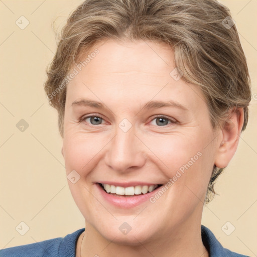 Joyful white young-adult female with short  brown hair and blue eyes