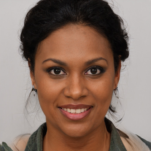 Joyful black young-adult female with long  brown hair and brown eyes