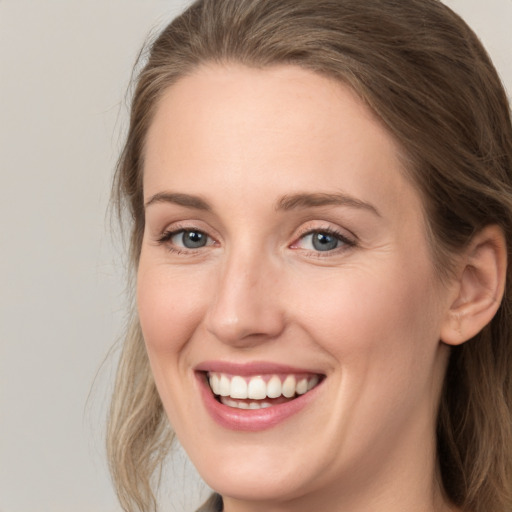 Joyful white young-adult female with long  brown hair and grey eyes