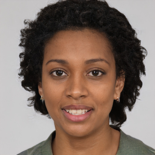 Joyful black young-adult female with long  black hair and brown eyes