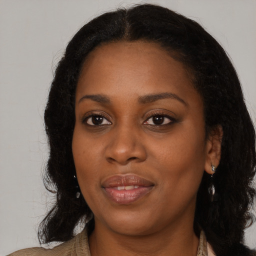 Joyful black young-adult female with long  black hair and brown eyes