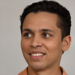 Joyful latino young-adult male with short  brown hair and brown eyes