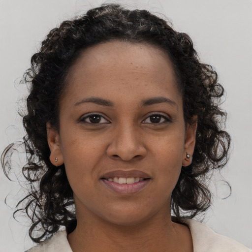 Joyful black young-adult female with medium  brown hair and brown eyes
