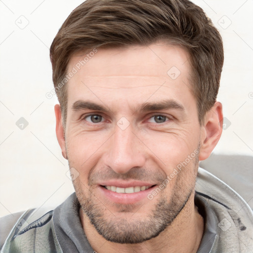 Joyful white young-adult male with short  brown hair and grey eyes