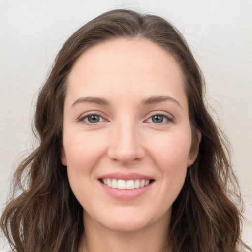 Joyful white young-adult female with long  brown hair and grey eyes