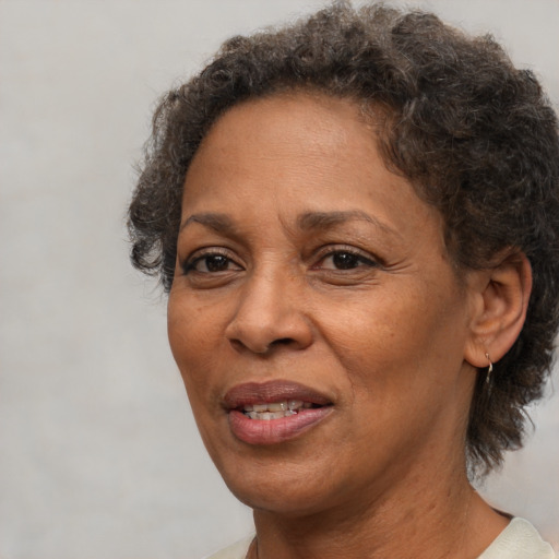 Joyful black adult female with short  brown hair and brown eyes
