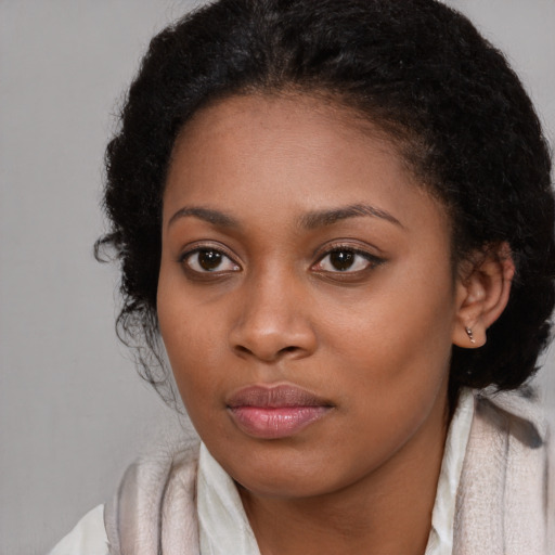 Joyful black young-adult female with long  brown hair and brown eyes