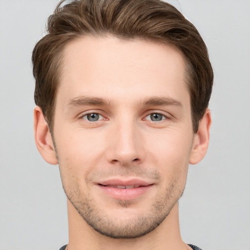 Joyful white young-adult male with short  brown hair and grey eyes