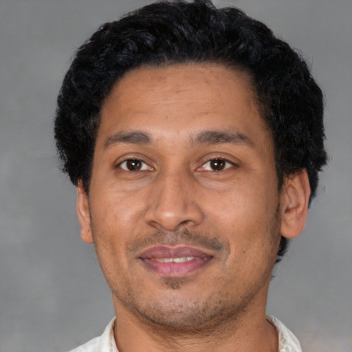Joyful latino young-adult male with short  black hair and brown eyes