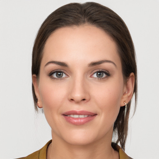 Joyful white young-adult female with medium  brown hair and grey eyes