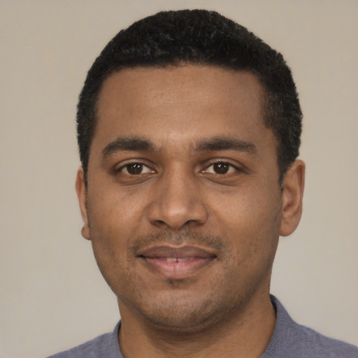 Joyful black young-adult male with short  black hair and brown eyes