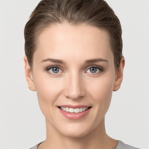 Joyful white young-adult female with short  brown hair and grey eyes