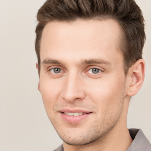 Joyful white young-adult male with short  brown hair and grey eyes