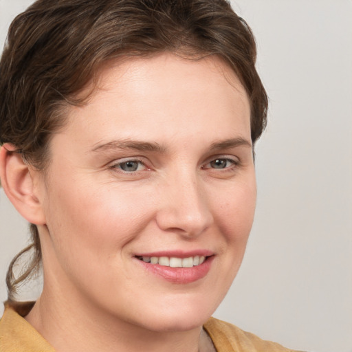 Joyful white young-adult female with short  brown hair and blue eyes