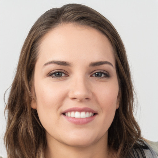 Joyful white young-adult female with long  brown hair and grey eyes