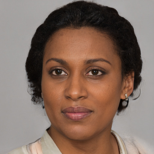 Joyful black adult female with short  brown hair and brown eyes