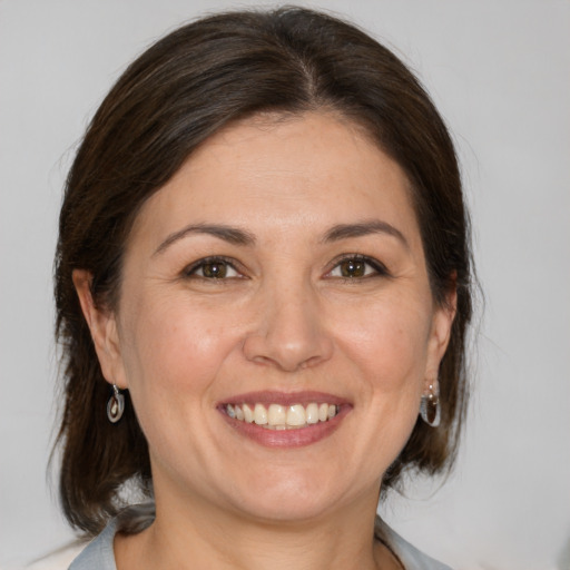 Joyful white adult female with medium  brown hair and brown eyes