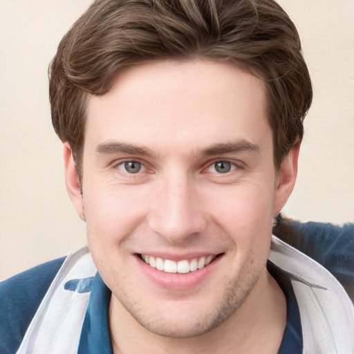 Joyful white young-adult male with short  brown hair and grey eyes