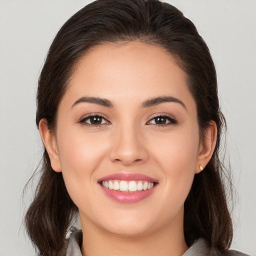 Joyful white young-adult female with long  brown hair and brown eyes