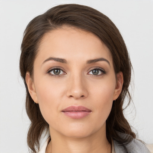 Joyful white young-adult female with medium  brown hair and grey eyes