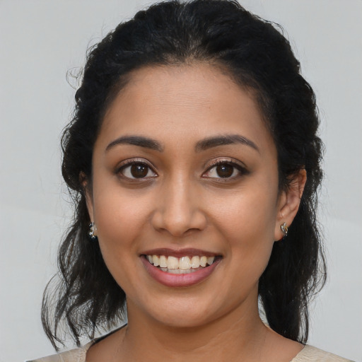 Joyful latino young-adult female with medium  brown hair and brown eyes