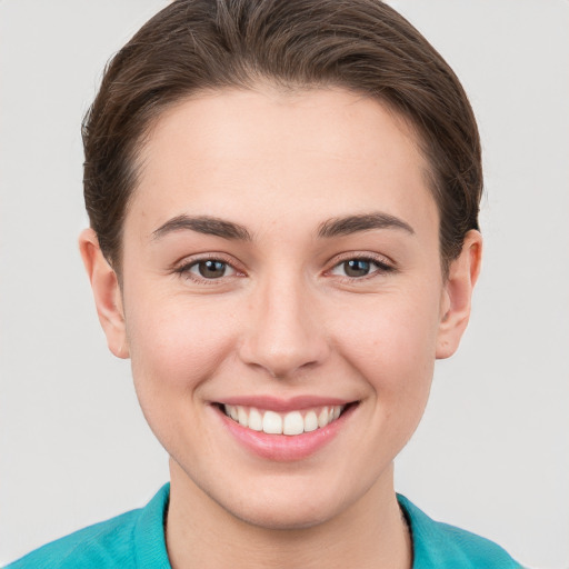 Joyful white young-adult female with short  brown hair and grey eyes