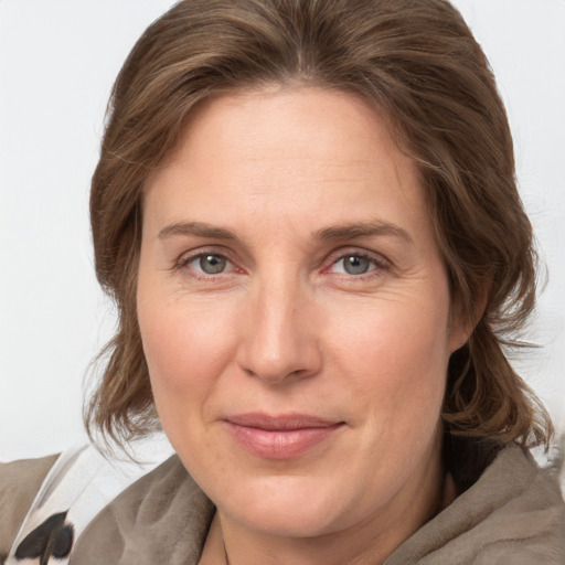 Joyful white adult female with medium  brown hair and grey eyes