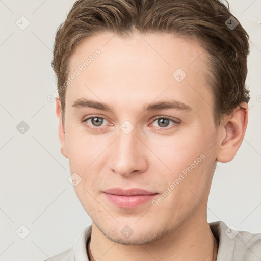 Joyful white young-adult male with short  brown hair and grey eyes