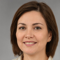 Joyful white adult female with medium  brown hair and brown eyes