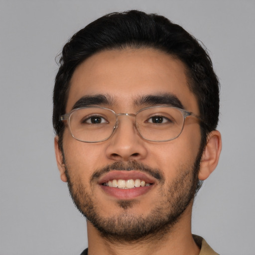 Joyful latino young-adult male with short  black hair and brown eyes