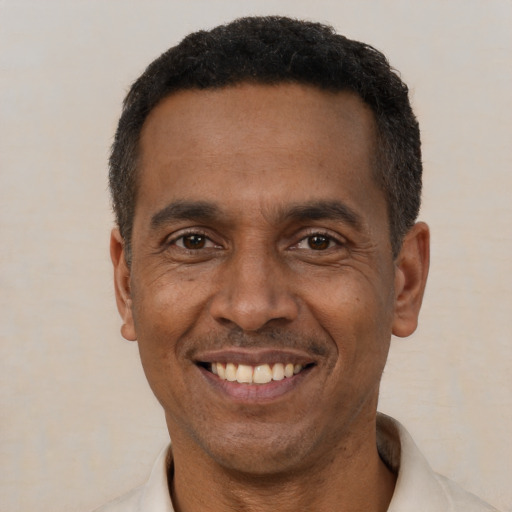 Joyful black adult male with short  black hair and brown eyes