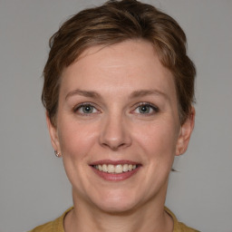 Joyful white adult female with medium  brown hair and blue eyes