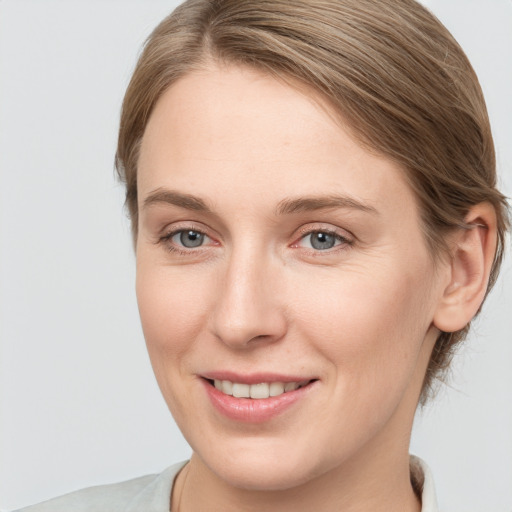 Joyful white young-adult female with medium  brown hair and grey eyes