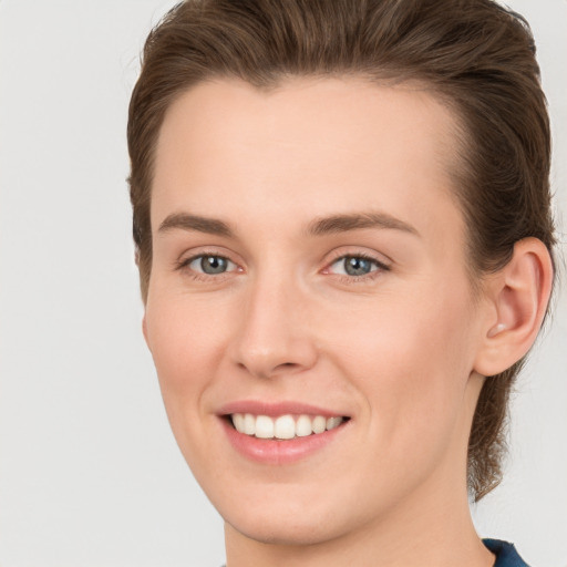 Joyful white young-adult female with short  brown hair and grey eyes