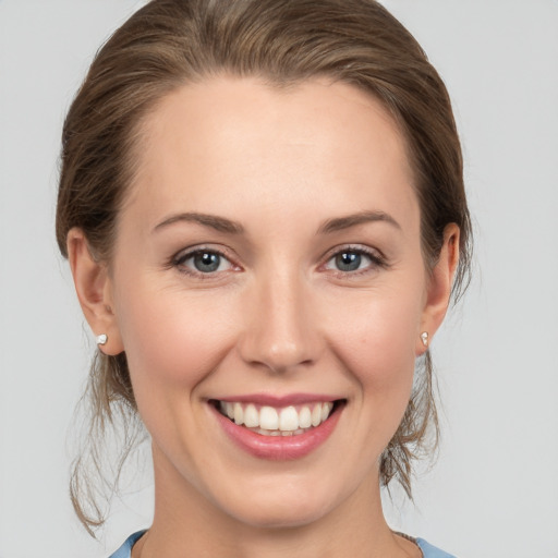 Joyful white young-adult female with medium  brown hair and grey eyes