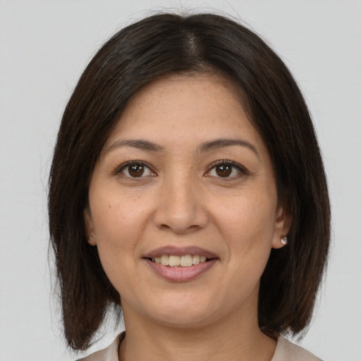 Joyful latino adult female with medium  brown hair and brown eyes