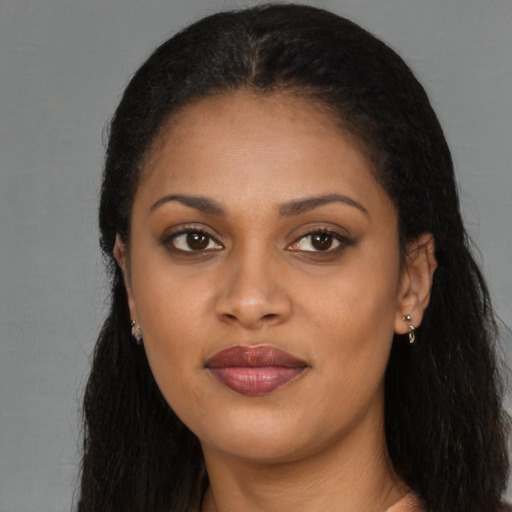 Joyful black young-adult female with long  brown hair and brown eyes