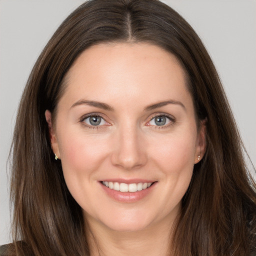 Joyful white young-adult female with long  brown hair and brown eyes