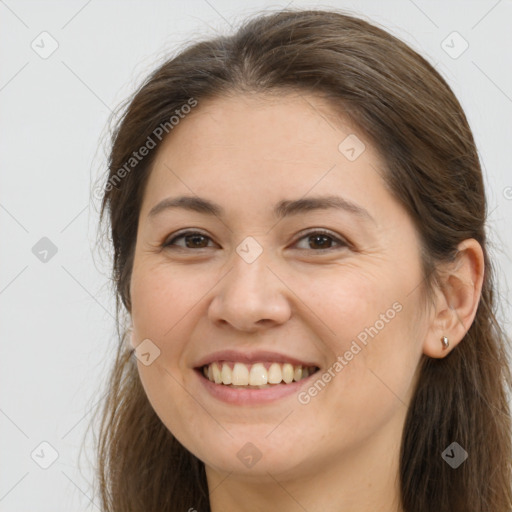 Joyful white young-adult female with long  brown hair and brown eyes