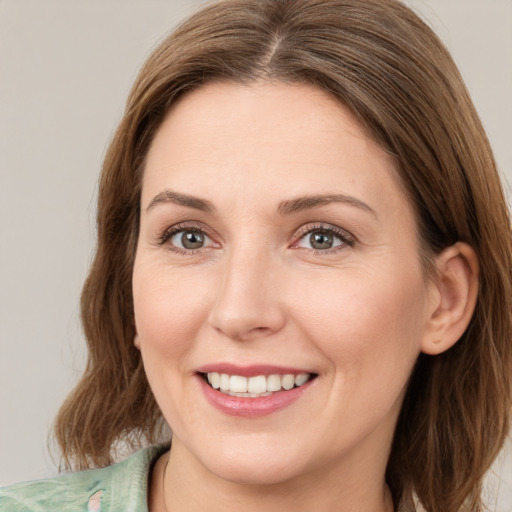 Joyful white young-adult female with medium  brown hair and green eyes