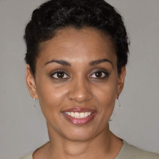 Joyful black young-adult female with short  brown hair and brown eyes