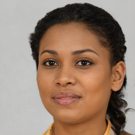 Joyful black young-adult female with long  brown hair and brown eyes