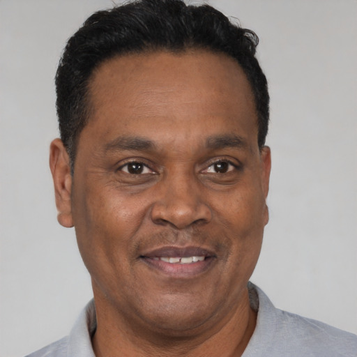 Joyful latino adult male with short  black hair and brown eyes