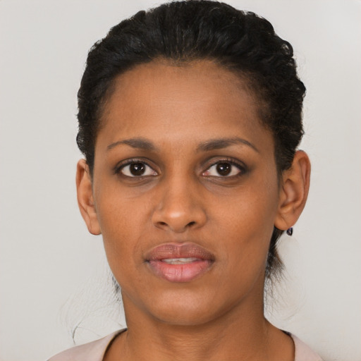 Joyful black young-adult female with short  black hair and brown eyes