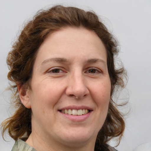 Joyful white adult female with medium  brown hair and grey eyes