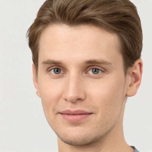 Joyful white young-adult male with short  brown hair and grey eyes